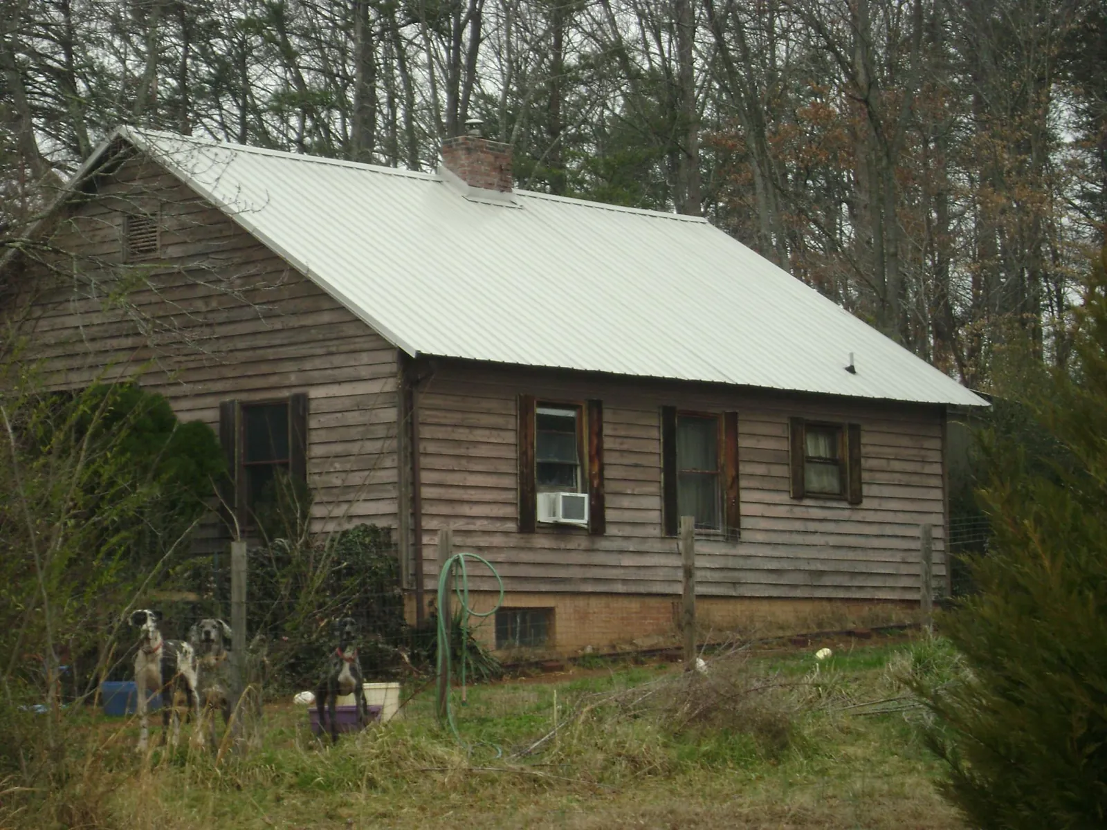 White metal roof on an old wood sided farmhouse, from a Metal Roof Installation job in Beaver Dam