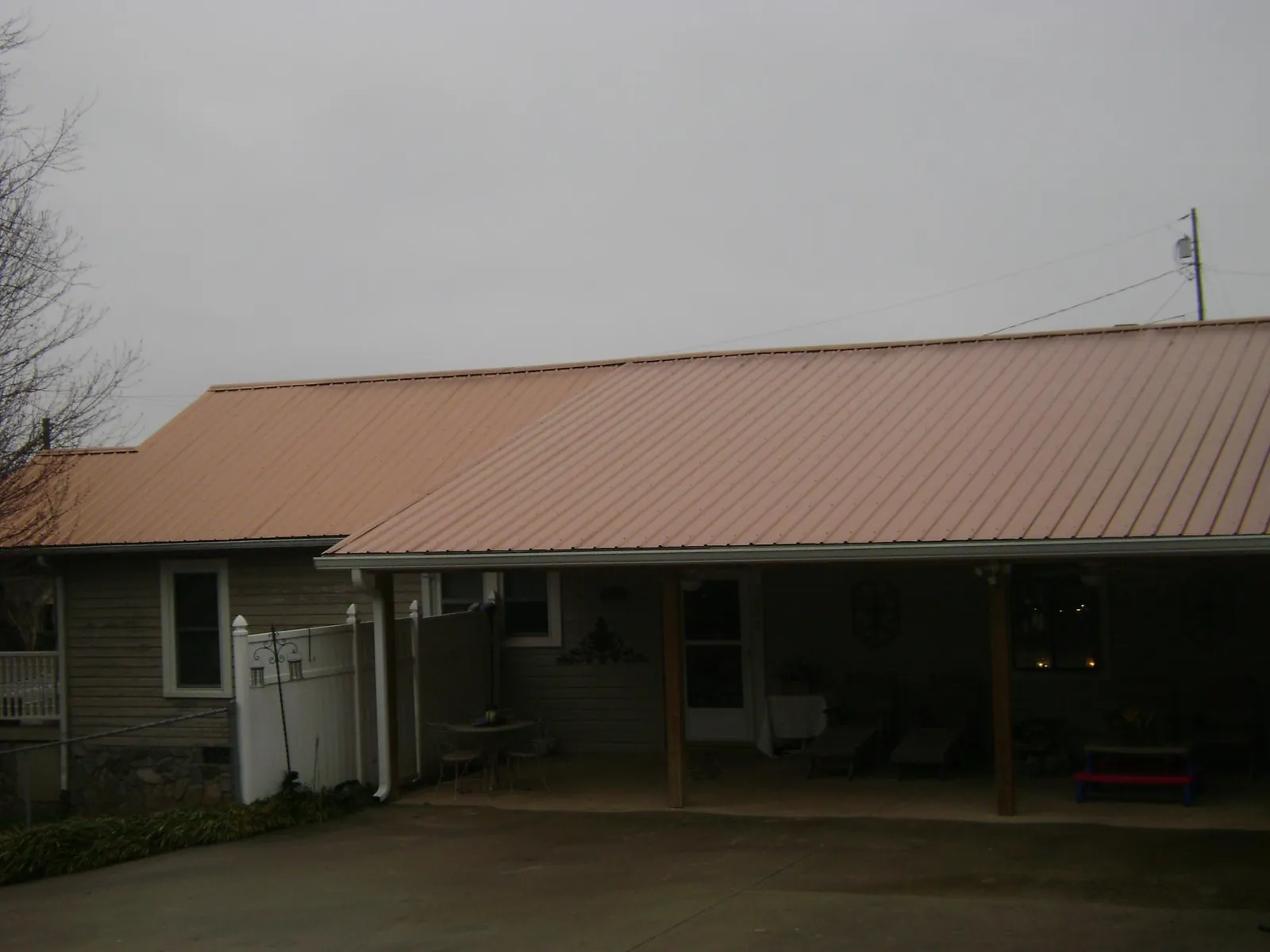 Copper toned metal roof over a wide covered patio in Beaver Dam